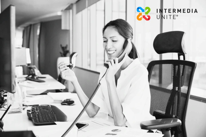 Employee handling a business call using a cloud-based phone system in an office environment.